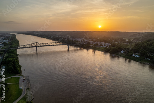 Sunset Over River with Small Town and Bridge