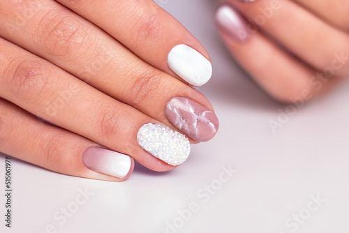  Close up view of beautiful female hands with luxury manicure nails  pink and white gel polish 
