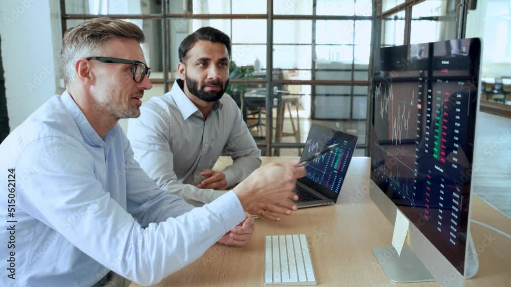 Two diverse crypto traders brokers stock exchange market investors discussing trading charts research reports growth using pc computer looking at screen analyzing invest strategy, financial risks.