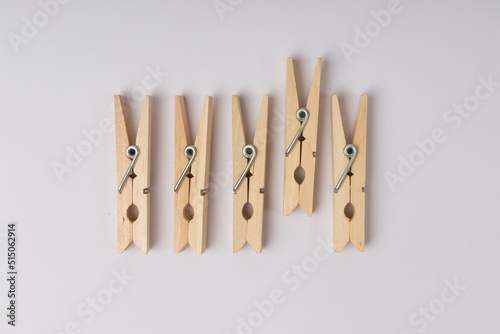 wooden clothespins lie in a row on a white background