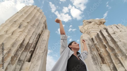 Free Happy Girl looking up with Raised Arms enjoying Calm on Nature. Pretty Young Woman Breathing Fresh Air, Feeling Pleasure and Connection with Nature while Wind Blowing. Freedom.