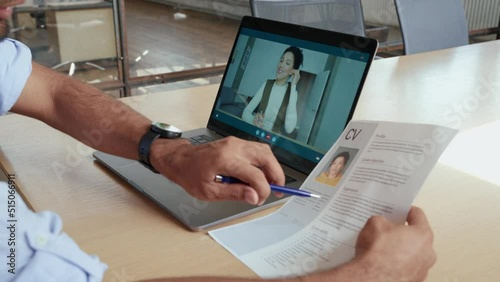 Indian human resource manager holding cv having virtual job interview conversation with remote female candidate during distant business video call on laptop computer. Online recruitment concept. 