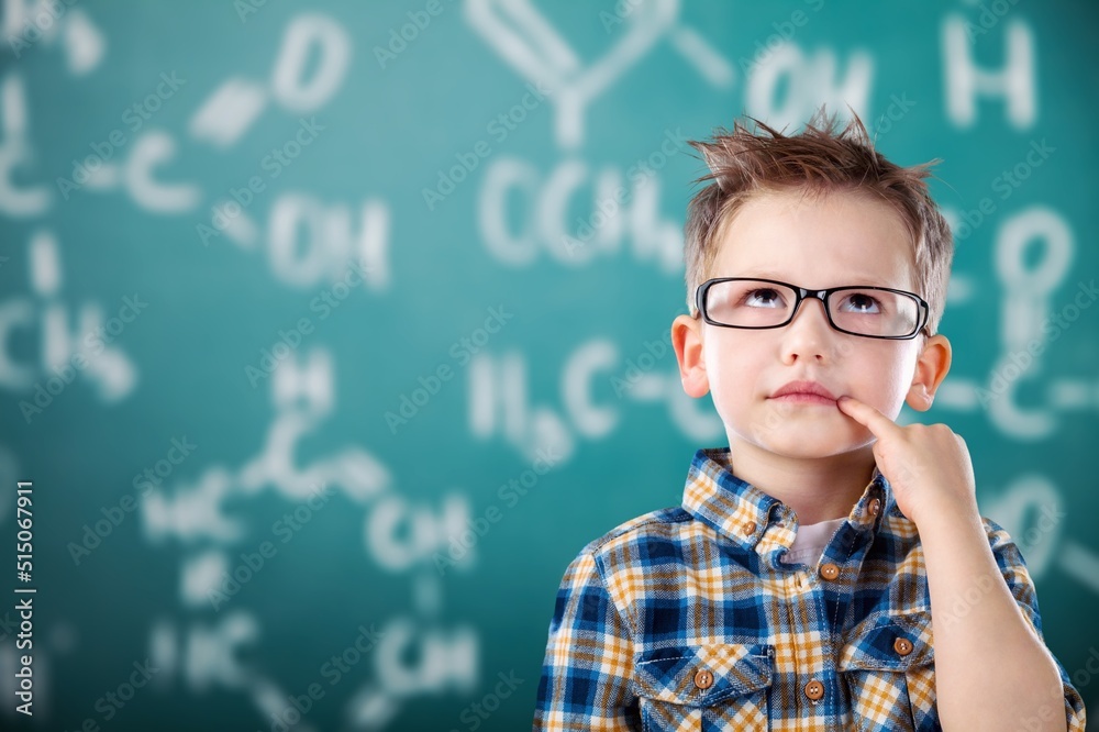 Happy academically gifted young child solving a math equation. Happy academically gifted young child solving a math equation.