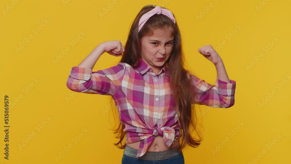 I am strong and independent. Fit sporty young preteen child girl kid showing biceps and looking confident, feeling power strength success win. Little toddler children alone on studio yellow background I am strong and independent. Fit sporty young preteen child girl kid showing biceps and looking confident, feeling power strength success win. Little toddler children alone on studio yellow background