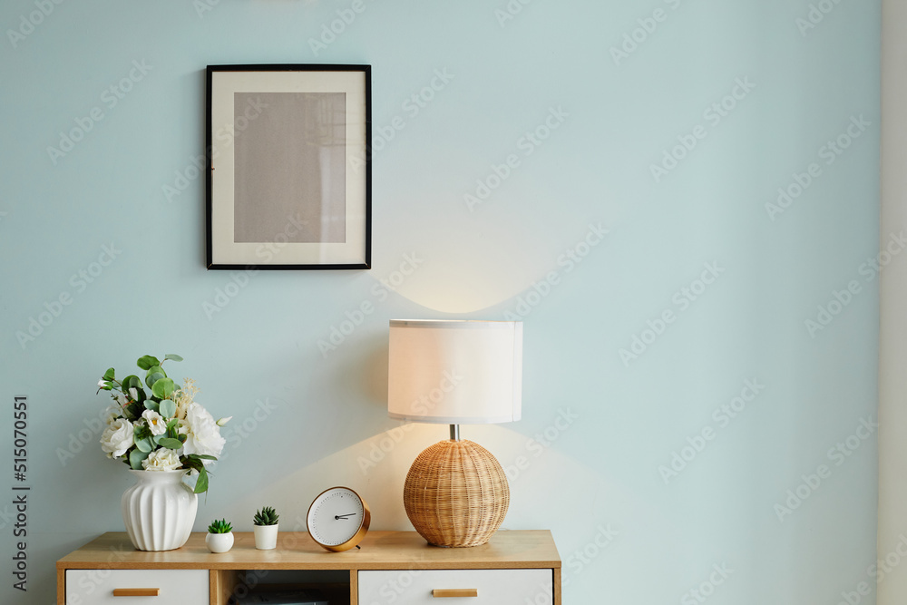 Background image of minimal home decor with flowers and mock up picture on wall, copy space - obrazy, fototapety, plakaty 