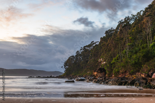 Dawn at the beach with headland and clouds