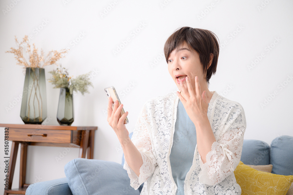 スマホを見て驚く女性