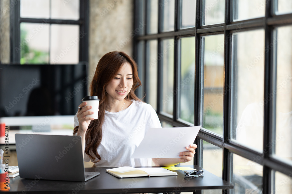 Serious beautiful young woman typing on laptop in a bright modern office, Charming asian businesswoman sitting working on laptop in office. Serious beautiful young woman typing on laptop in a bright modern office, Charming asian businesswoman sitting working on laptop in office.