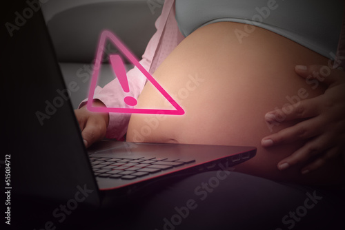 Concept pregnancy, pregnant woman receiving alert on laptop