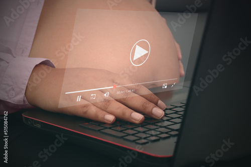 Concept business streaming service, pregnant woman watching video on internet, live concert, show or tutorial