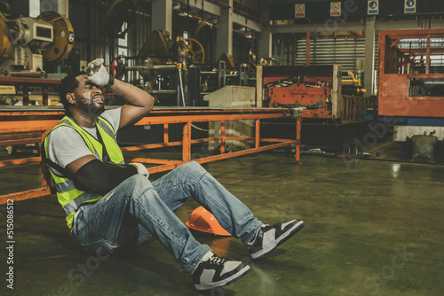 African American male worker with right arm injury wears cast can't work has to take sick leave for medical treatment : Male workers insured against work accidents that occur in factories. photo