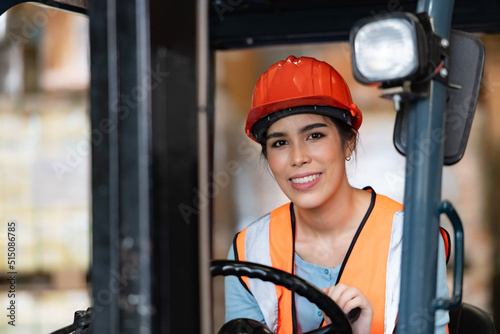 Portrait of an Asian woman with a forklift used to lift heavy objects in a warehouse. photo