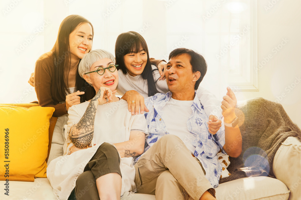 Perfect happy family : Portrait large Asian parent and healthy sister sitting on the sofa relaxing on the sofa. Take pictures at home good mood Spend time together having fun and having fun. Perfect happy family : Portrait large Asian parent and healthy sister sitting on the sofa relaxing on the sofa. Take pictures at home good mood Spend time together having fun and having fun.