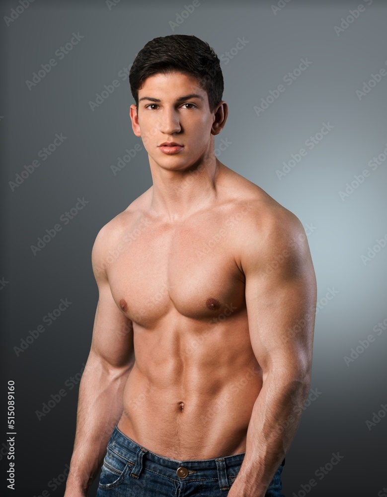 Young handsome athlete man standing against a background.