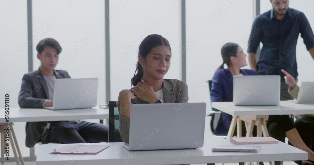 business woman stretch After sitting for hours at work. A young woman sits at a desk using a laptop to work. He works hard and is tired at the office. technology to help work concept business woman stretch After sitting for hours at work. A young woman sits at a desk using a laptop to work. He works hard and is tired at the office. technology to help work concept