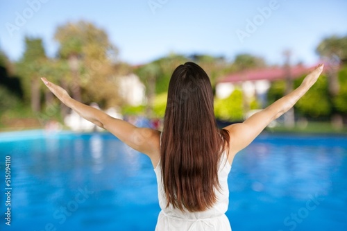 Happy woman stands on the viewpoint and enjoys the panorama of resort town