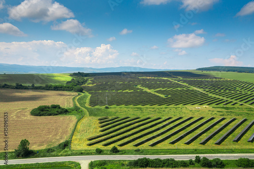 Aerial texture view with a big solar panel plant on top of the hills. Summer industrial landscape with a plant that produce electricity from the sunlight. Green eco energy industry.