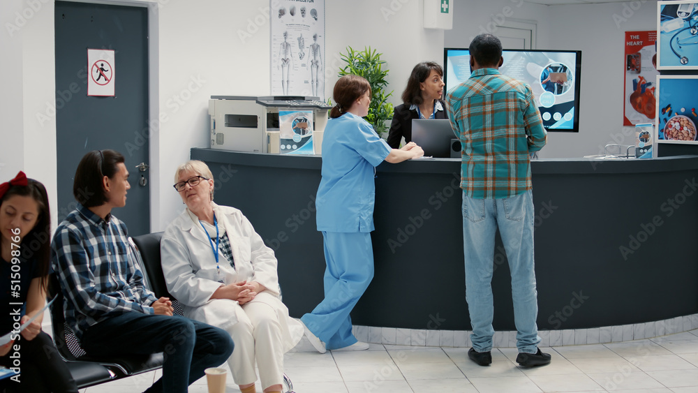 Diverse group of patients sitting in waiting room area to register for