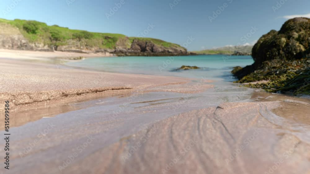 Close up shot of water steadily flowing across a beach and into a turquoise ocean, eroding the sand to form beautiful, branching organic shapes. Handa Island, Scotland. Close up shot of water steadily flowing across a beach and into a turquoise ocean, eroding the sand to form beautiful, branching organic shapes. Handa Island, Scotland.