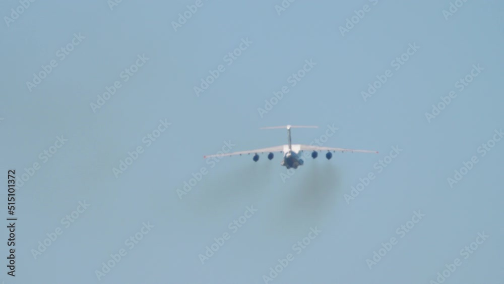 Transport heavy aircraft climb after takeoff, long shot rear view. Multipurpose fixed-wing four-engine turbofan strategic aircraft Transport heavy aircraft climb after takeoff, long shot rear view. Multipurpose fixed-wing four-engine turbofan strategic aircraft