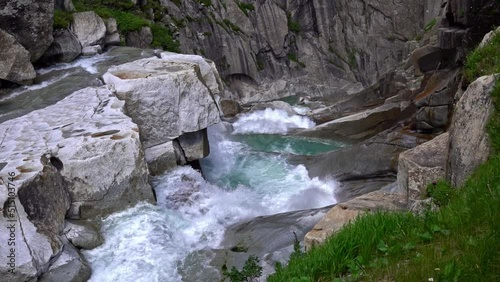 Beautiful waterfall cascade at famous Schöllenen Canyon, Canton Uri, on a sunny summer day. Slow motion movie shot July 3rd, 2022, Andermatt, Switzerland. photo