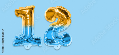 Rainbow foil balloon number, digit twelve on a blue background. Birthday greeting card with inscription 12. Top view. Numerical digit. Celebration event, template. Banner