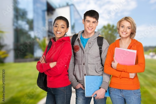 Education concept. Group smiling students with books and backpacks at walking in university campus.