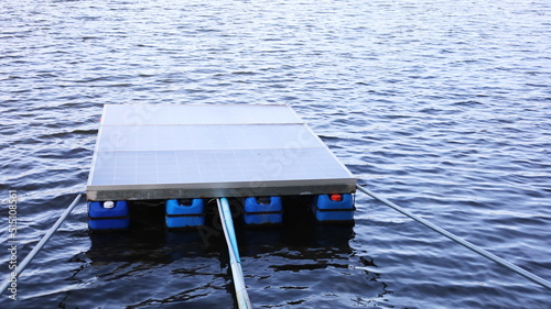 Floating solar panels. Close-up of a group of photovoltaic panels floating on lake water as renewable or clean alternative energy with copy space. Selective focus photo
