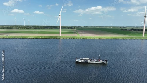 Recreational leisure boat sailing along coast with wind turbines. Vessel ship photo