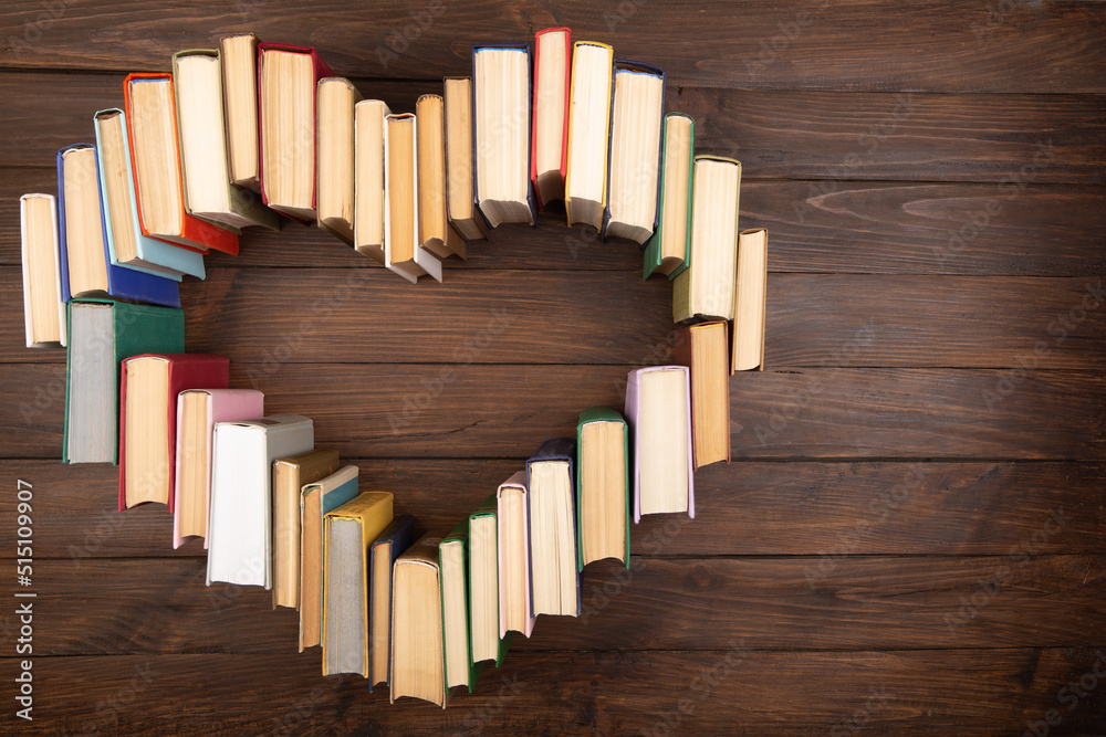 Love of reading concept. Book heart on the wooden background. Copy space for text Love of reading concept. Book heart on the wooden background. Copy space for text