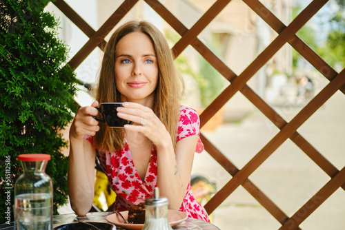 Young woman hold cup of coffee in hand sitting on the terrace photo