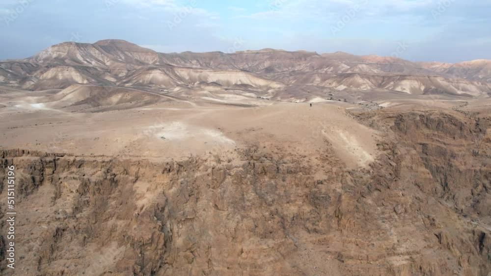 Man walking on a cliff in a desert landscape. Man walking on a cliff in a desert landscape.