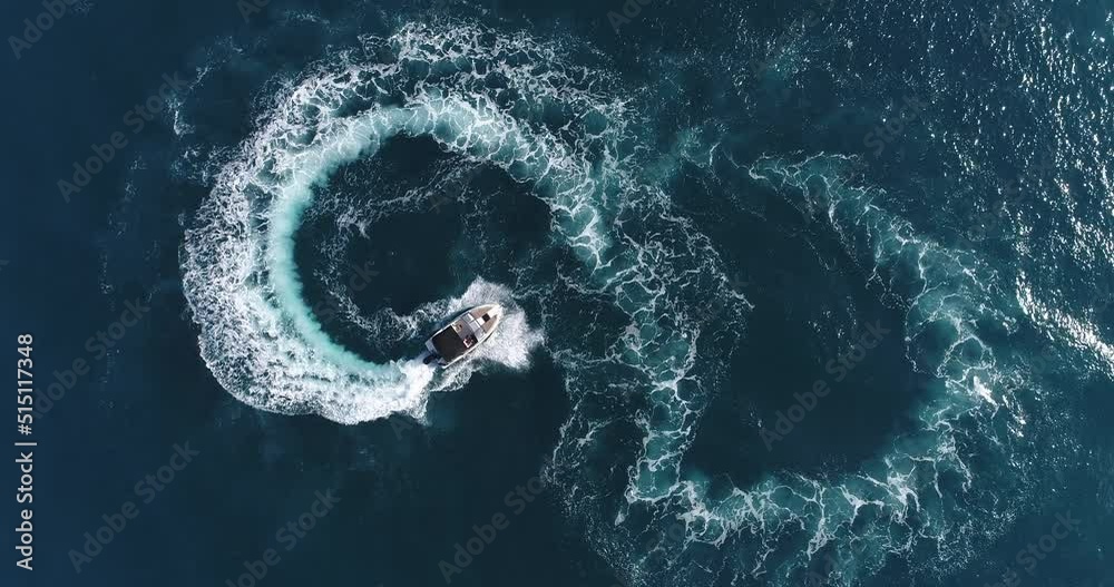 Aerial top view of a white pleasure boat on a summer day. Powerboat turn loop eight on the sea making metaverse infinity future concept. 