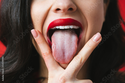 Obraz na plátně Image of a woman sticking her tongue out between the fingers