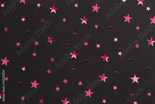 Festive pink golden stars on black decorating paper background. Backdrop for postcards or banners. New year 2023 decoration packaging. Merry xmas or birthday concept © Lavsketch