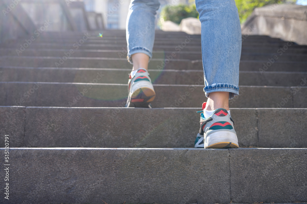 Female tourist in casual clothes going upstairs outdoors