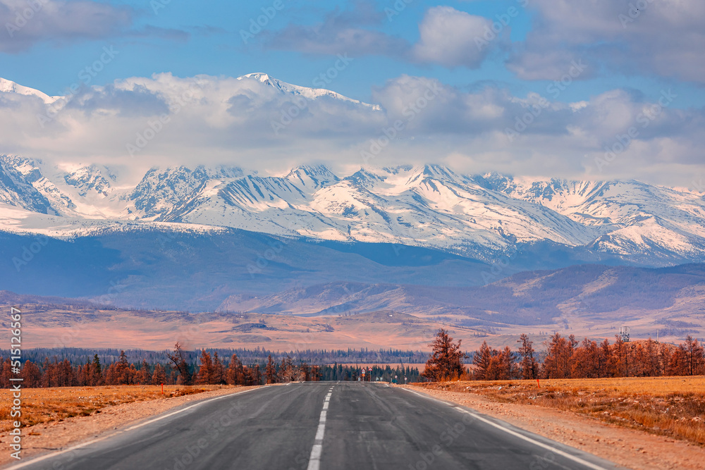 Beautiful landscape road in autumn forest with snow peaks mountains Chuysky tract, Altai Kurai steppe Russia.