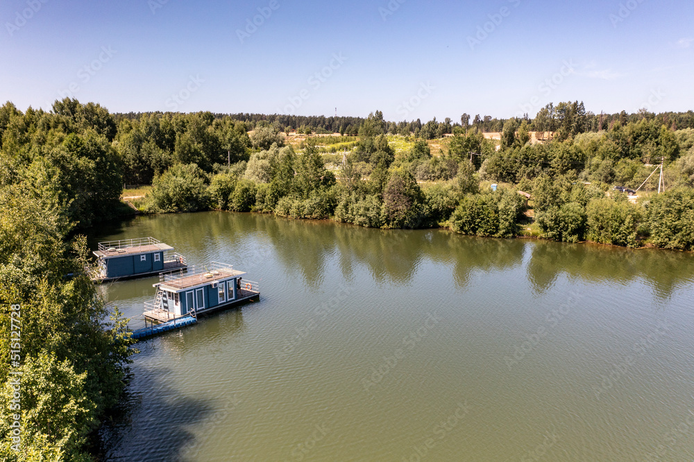 a panoramic view of the green forest and the lake and the glampings standing on the shore on a sunny summer day taken from a drone a panoramic view of the green forest and the lake and the glampings standing on the shore on a sunny summer day taken from a drone