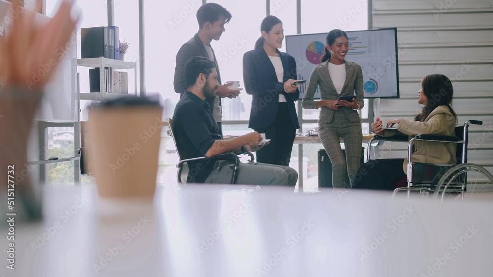 A disabled company employee is able to work happily with colleagues in the office.