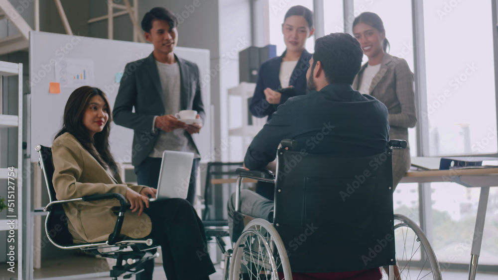 A disabled company employee is able to work happily with colleagues in the office. A disabled company employee is able to work happily with colleagues in the office.