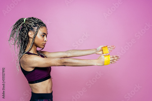 Beautiful girl doing exercises and sport. Posing on a pink colored background
