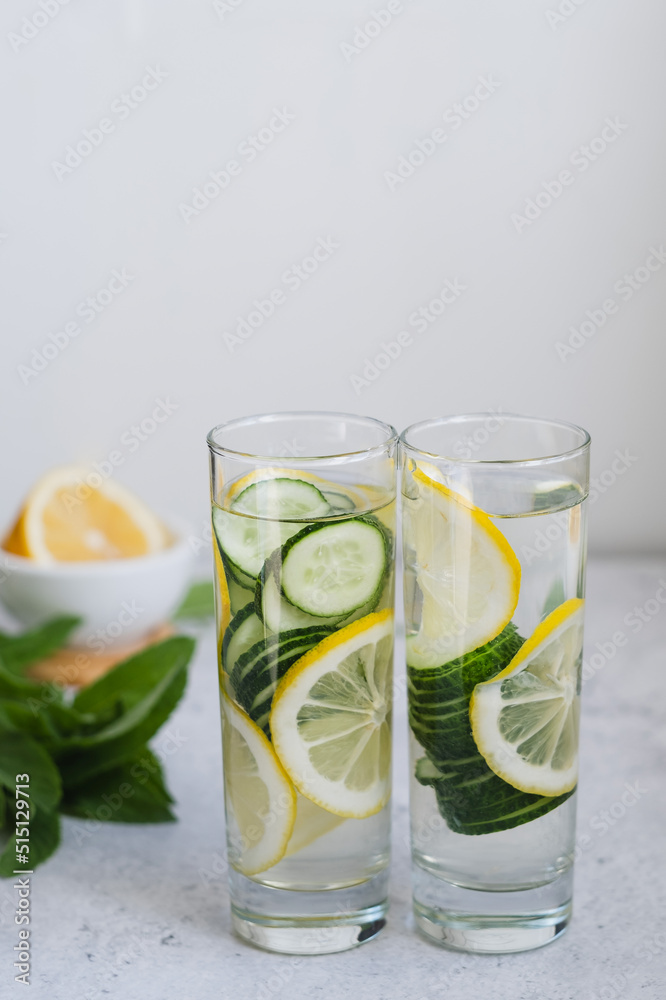 Two long glasses of infused cucumber water with lemon and mint. Hard light. copyspace Two long glasses of infused cucumber water with lemon and mint. Hard light. copyspace