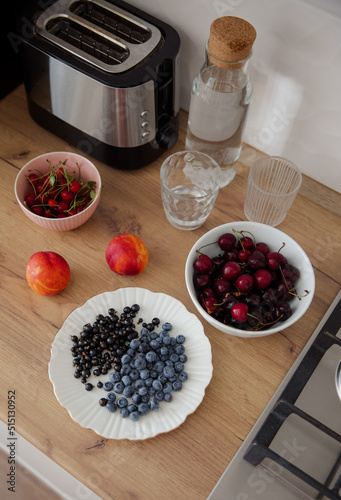 Obraz na płótnie Fresh summer berries on beautiful plates. Berries and fruits for a light breakfast in the kitchen. Healthy food. Cherry, cherry, blueberry, currant and nectarine w salonie
