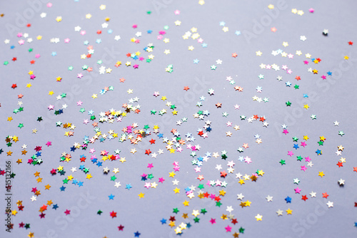 multicolor sparkles on a purple background. Festive backdrop for your projects.