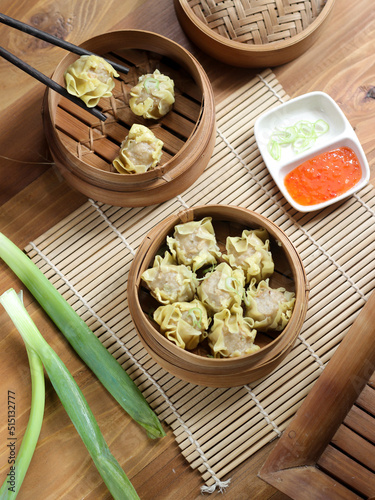 Siomay ayam, steamed dumpling dimsum with the main ingredients of chicken and shrimp. Served in traditional bamboo steamer on white background