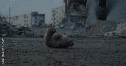 Kid's teddy bear lost among ruins of the bombed city photo