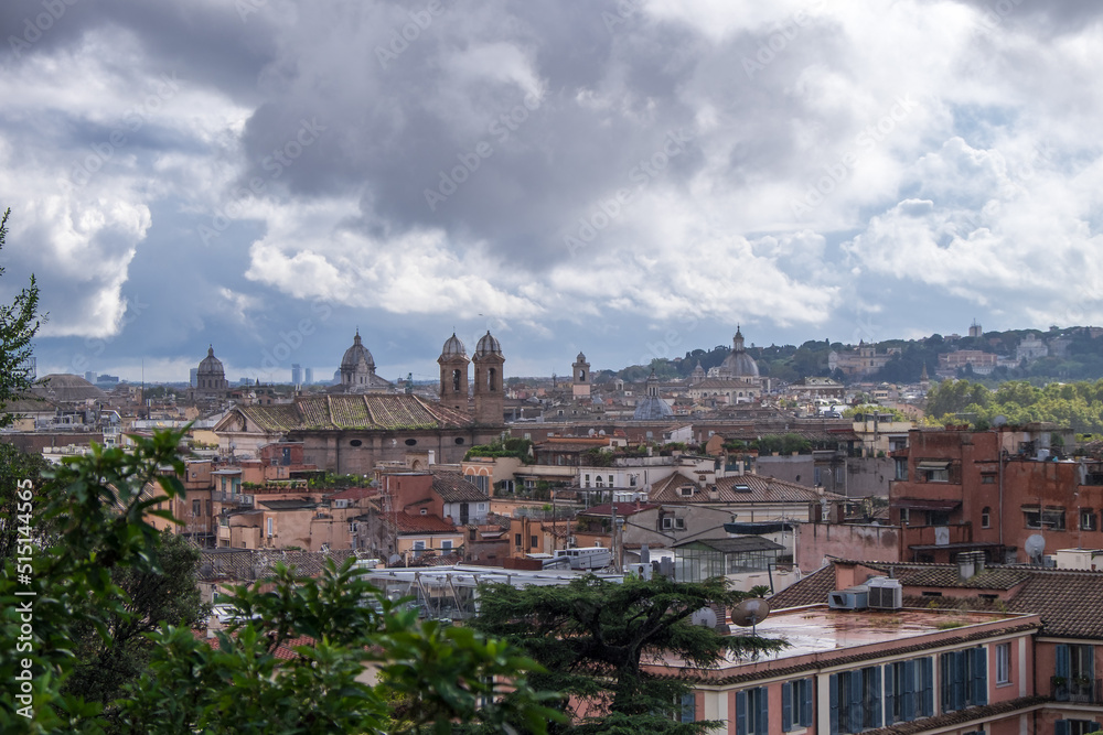 Roofs of Rome with cupolas of ancient churches in the distance. Shot on a rainy day with stormy clouds 