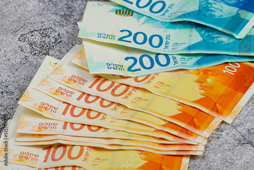 Slika na platnu Banknotes of 100 Israeli shekels lie on the table close-up.