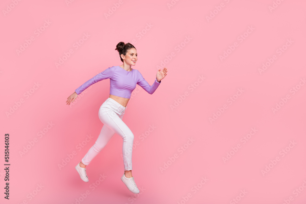 Full length profile photo of excited active girl look empty space rush fast isolated on pink color background Full length profile photo of excited active girl look empty space rush fast isolated on pink color background