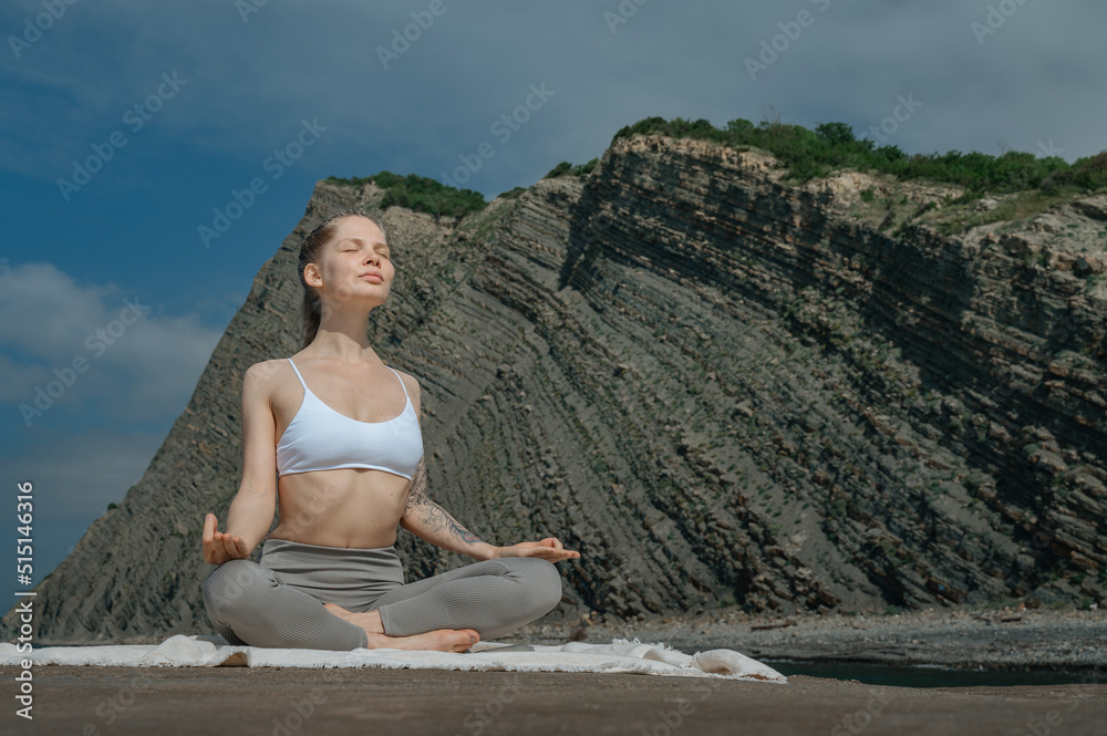 Yoga practice and meditation in nature. Woman practicing near Black sea.